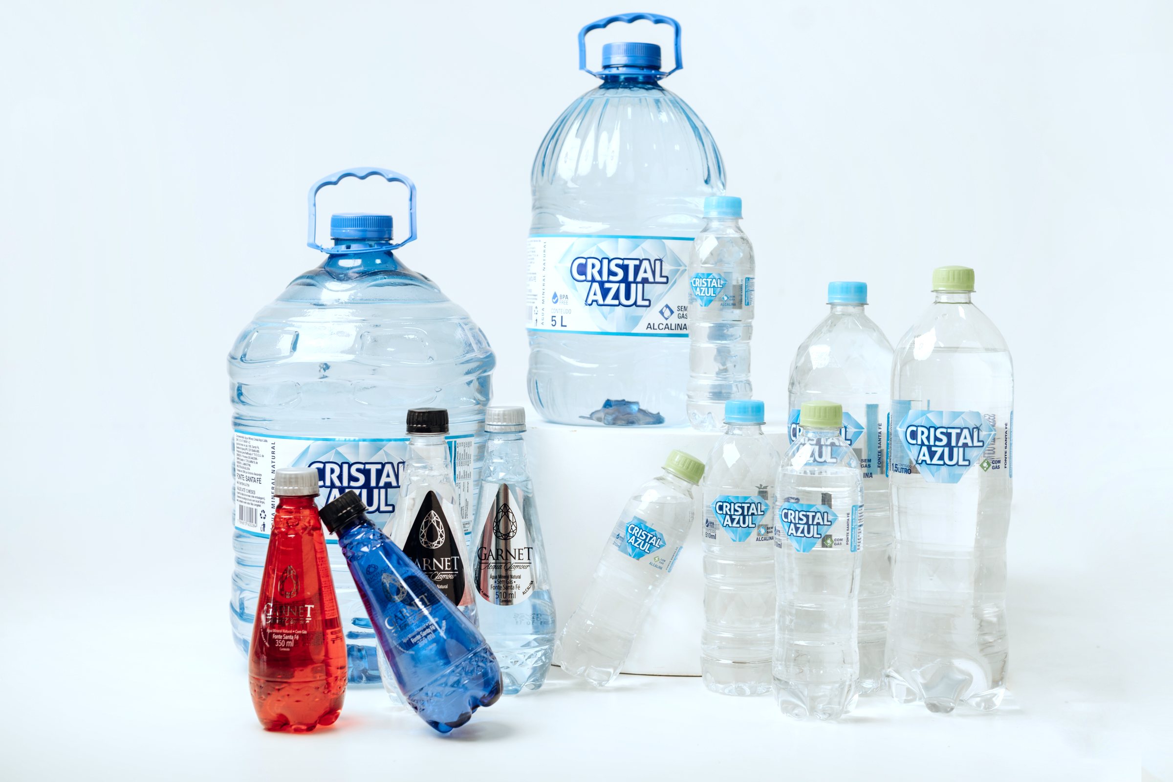 Linha Cristal Azul e Garnet em estúdio: galões de 10 L e 5 L, garrafas de 1,5 L e 510 ml e as garrafas Garnet